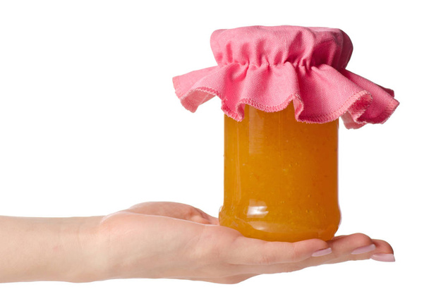 Orange apricot peachy jam in a jar cover in hand - Φωτογραφία, εικόνα