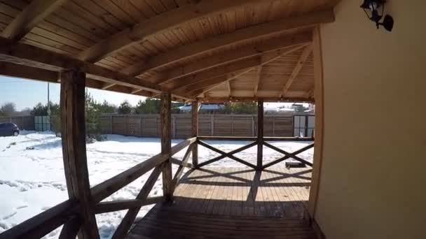 Holzterrasse in der Hütte mit Blick auf die Kiefern im Winter. große Holzterrasse in traditionellem Chalet mit Panoramafenstern und Pinienwald - Filmmaterial, Video
