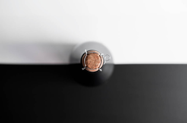 a bottle of champagne with a closed stopper view from the top on a black - white background concept - Zdjęcie, obraz