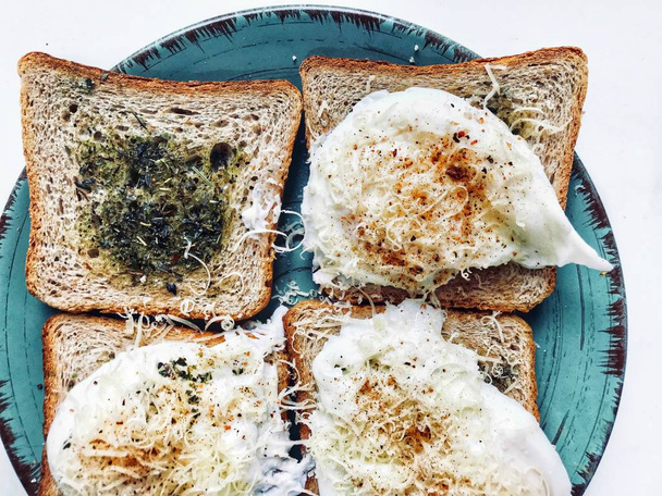 Smakelijke Engels ontbijt gemaakt van toast met kruiden en gepocheerde Benedict eieren met Parmezaanse kaas en peper - Foto, afbeelding