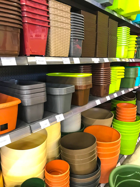 Пластиковые горшки и коробки на полках на рынке
 - Фото, изображение