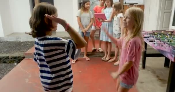 Twee jonge meisjes hoge vijf en samen met hun diverse groep van gemengd ras vrienden - Video