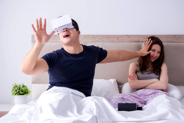vrouw en man met virtual reality bril in het bed - Foto, afbeelding