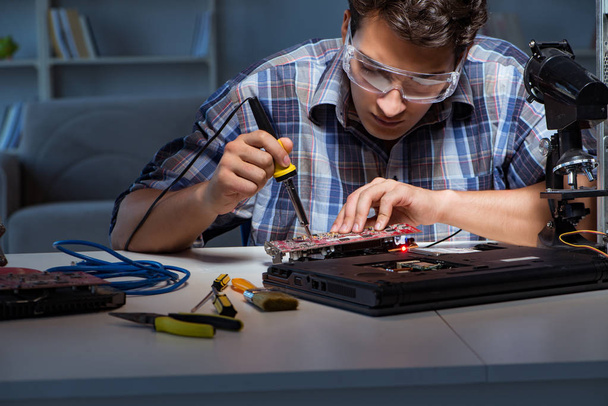 Jovem técnico de reparação de soldagem de peças elétricas em motherboar - Foto, Imagem