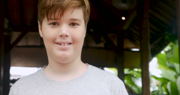 Egy 12-13 éves fiú mosolyogva szeplőkkel portréja - Felvétel, videó