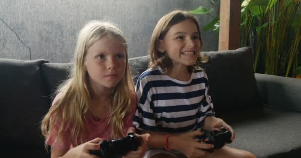 Two happy smiling young girls playing a video game together - Záběry, video