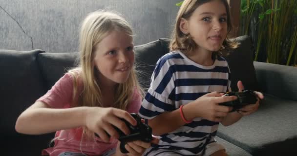 Authentic moment between two young pre teenage girls playing video games - Filmati, video