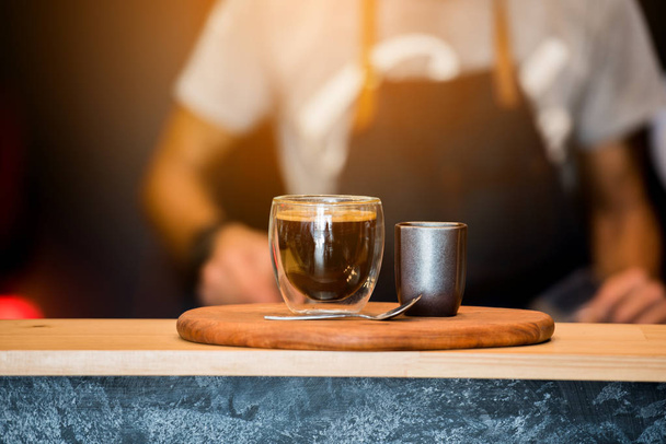 Tasse à café noire sur table en bois et café Barista.. Horizontal.Blurred Background.Film effet
. - Photo, image