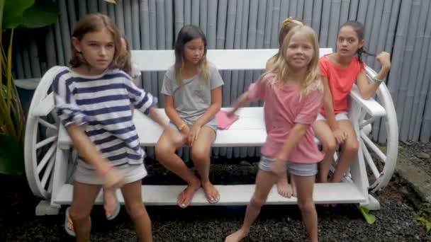 Diverse groep van jonge meisjes afstappen van een bankje aan hun vriend dansen - Video
