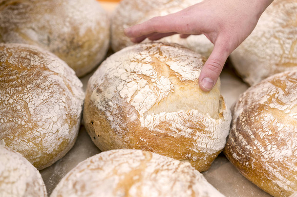 Käsi kurkottaa leipää myymälässä
 - Valokuva, kuva