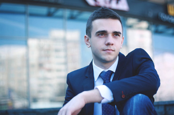 young businessman sitting on the steps of the office - Foto, Imagem