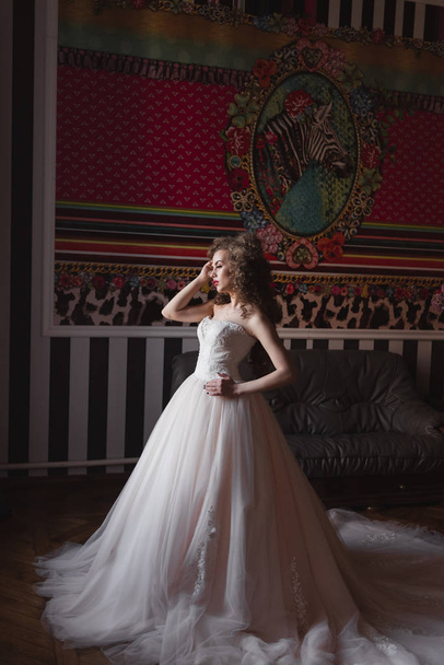 curly bride standing in a room dressed in a wedding dress - Photo, Image
