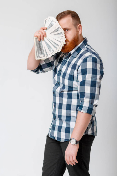 man with beard holding lot of hundred-dollar bills - Foto, Imagen