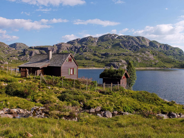 A house near a mountain lake. High in the Norwegian mountains are villas of local residents. - 写真・画像