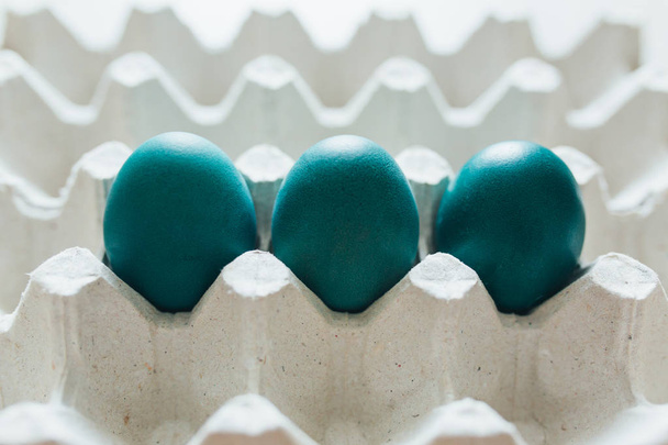 Пасхальные яйца разных цветов в лотке
 - Фото, изображение