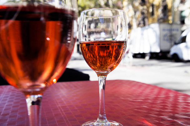 két pohár vörös bor az asztalon egy utcai kávézó egy ragyogó napsütéses napon - Fotó, kép