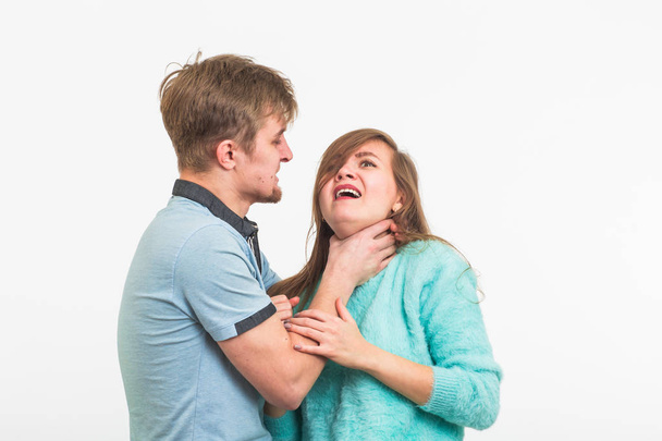 Woman victim of domestic violence and abuse. The quarrel in the family. A man beats a young woman on white background - Foto, Bild