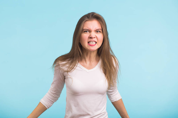 Angry agresivní žena s divokým výrazem na modrém pozadí - Fotografie, Obrázek