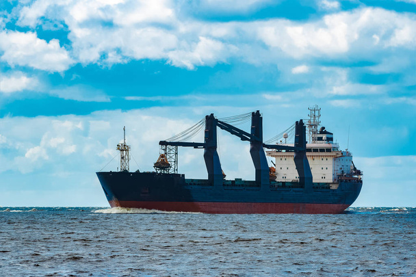 Warenimport. großes blaues Frachtschiff bewegt sich in Riga Port - Foto, Bild