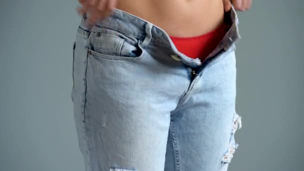 Vrouw in rode ondergoed trekt op blue jeans - Video