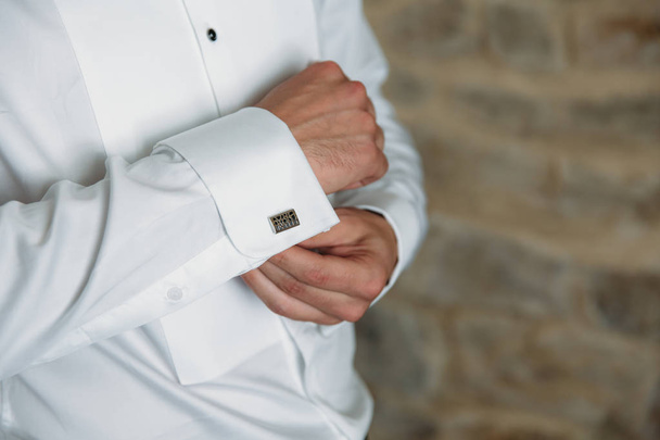 Groom hands with cufflinks. Elegant gentleman clother, white shirt and black belt - Fotó, kép