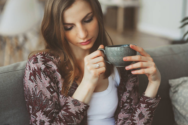 Portret młodej kobiety miło filiżankę kawy lub herbaty siedzi sama w domu z bliska. Depresja i koncepcja zdrowia psychicznego - Zdjęcie, obraz