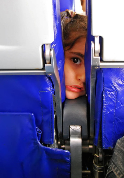 Küçük kız kameraya doğrudan uçak koltukları ile komik sahne - Fotoğraf, Görsel