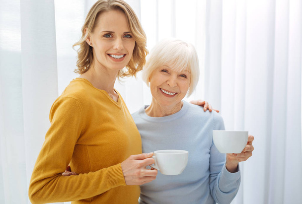 Joyful friendly relatives drinking tea and being in a good mood - Fotó, kép