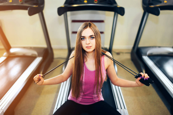Pretty sporty girl with long hair training in the gym - Photo, Image