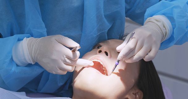 Paciente revisando sus dientes con espejo en la clínica dental
  - Foto, Imagen