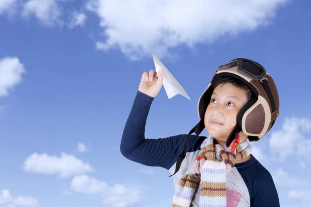 asiático chico usando vintage vuelo casco celebración un avión papel
 - Foto, imagen
