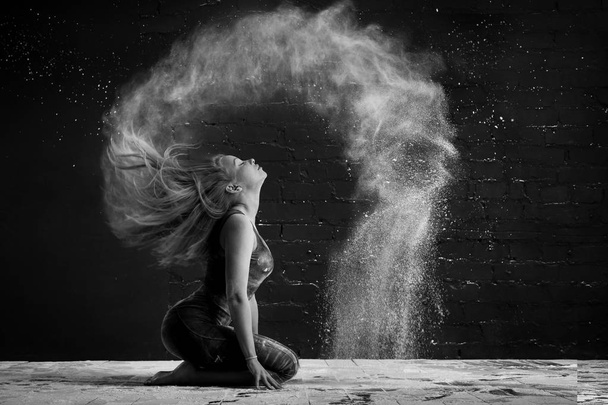 girl in a cloud of dust outlines an arc wave of hair. black and white photo - Foto, immagini
