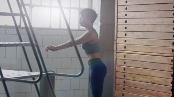 młody dopasowanie i dźwięk kobieta robi ogrzewanie przed treningiem fitness w słoneczny loft - Materiał filmowy, wideo