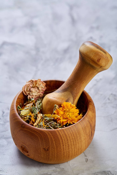 Spa still life with flowers in wooden bowl on light textured background, top view, close-up, selective focus - 写真・画像