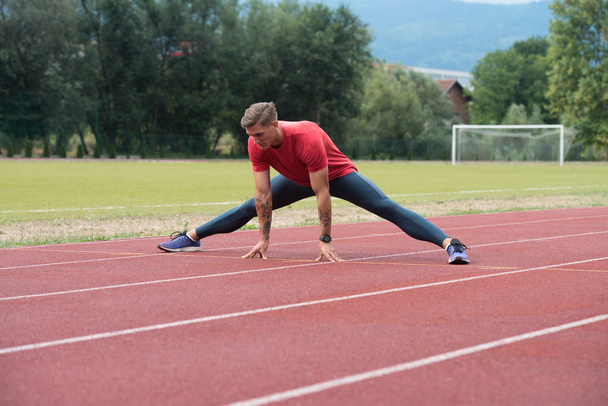 Athletic Runner Doing Stretching Exercise - Foto, Imagen