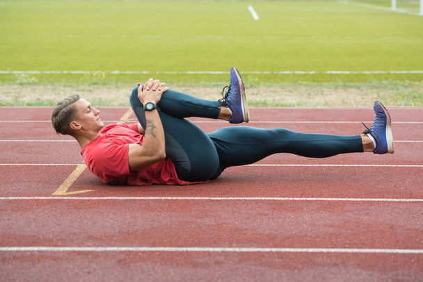 Male Runner Stretching Before Workout - Foto, imagen