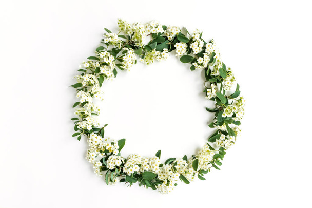 Kukkivat kukka seppele Spirea arguta (morsiamet kasvi) valkoisella pöydällä. Tasainen, ylhäältä
 - Valokuva, kuva