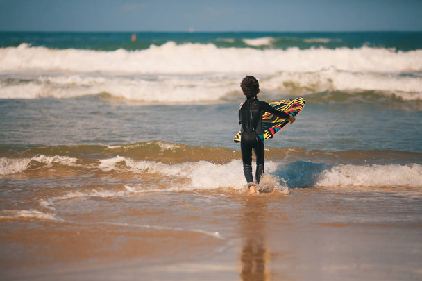 Young surfer, happy young boy in the ocean on surfboard - Foto, Imagen