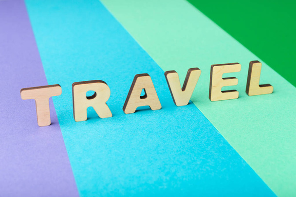 Palabra de viaje inscrita con letras de madera sobre fondo colorido
 - Foto, imagen