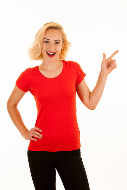 Attractive beautiful young blonde woman pointing into copyspace  - Фото, изображение