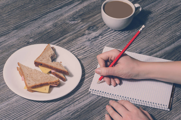 手書きのノートに。仕事で中断します。チーズ卵サンドイッチ プレート、コーヒー カップの背景。上面ビュー、ビンテージ スタイル - 写真・画像