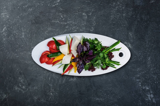 Goat cheese with sliced vegetables served on the white plate. - Fotografie, Obrázek