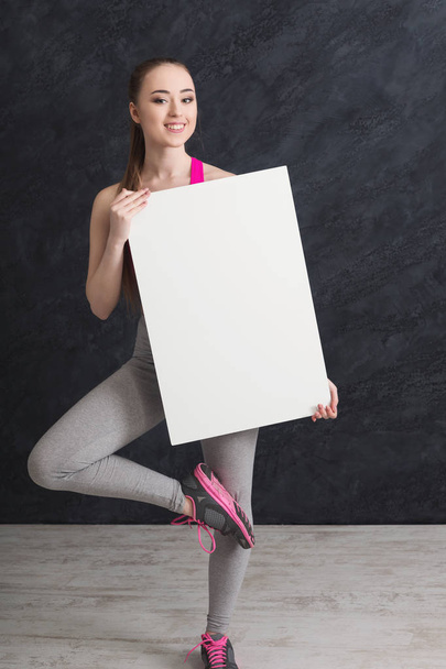 Młoda kobieta sportowy z biała kartka papieru - Zdjęcie, obraz