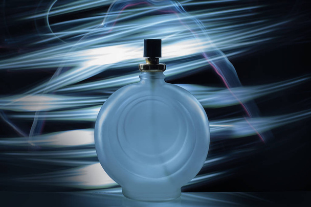 üveg Köln parfüm, a fény kék háttér - Fotó, kép