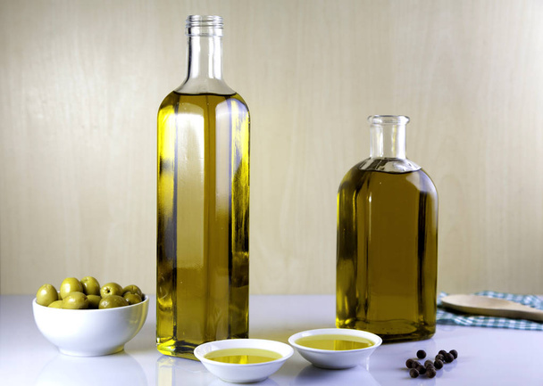 Két üveg olívaolaj, olajbogyó tál - Fotó, kép