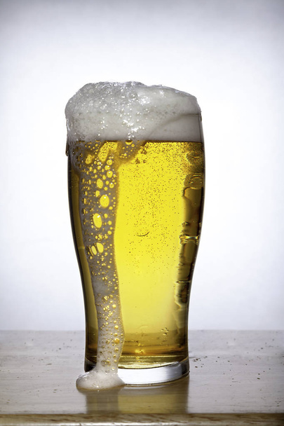 Ποτήρι μπύρας με αφρό σε λευκό - Φωτογραφία, εικόνα