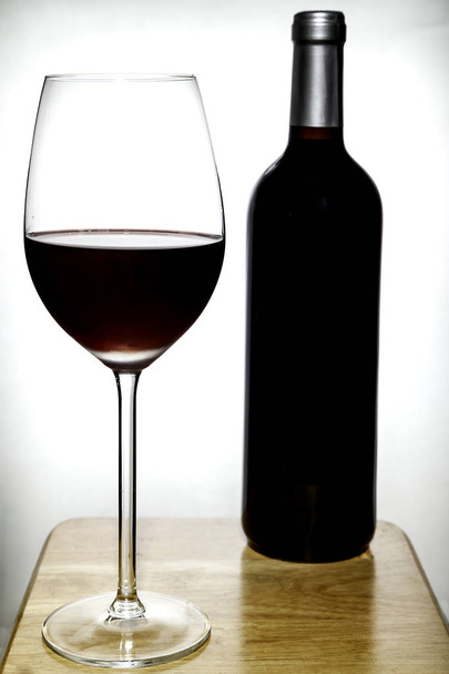 glass and bottle of red wine on white - Фото, зображення