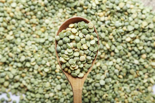 green peas in a wooden spoon - Fotó, kép