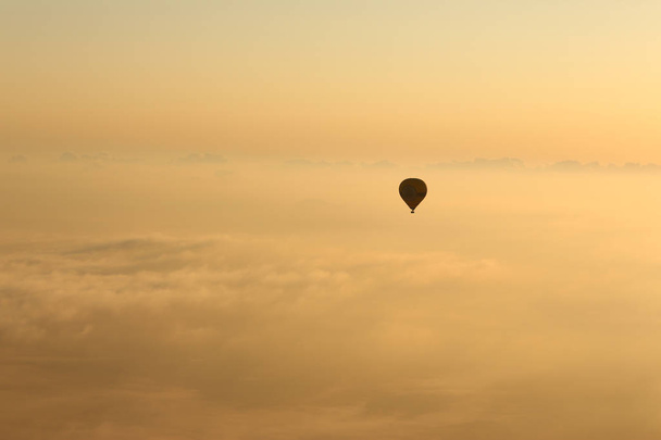 Heißluftballons, Stimmungsballons, die im Sonnenaufgang über die Berglandschaft Mallorcas fliegen - Foto, Bild