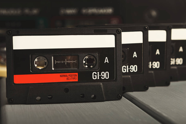 Fila de casetes de audio vintage y grabadora de cinta en fondo gris
 - Foto, imagen
